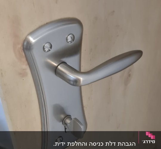 ידית דלת מתכתית עם מנעול על דלת עץ
